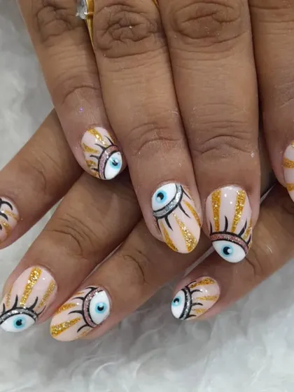 Express your unique style with our custom hand-painted nail art. This design features the popular evil eye motif, detailed with fine lines and gold glitter accents on a natural, almond-shaped nail.