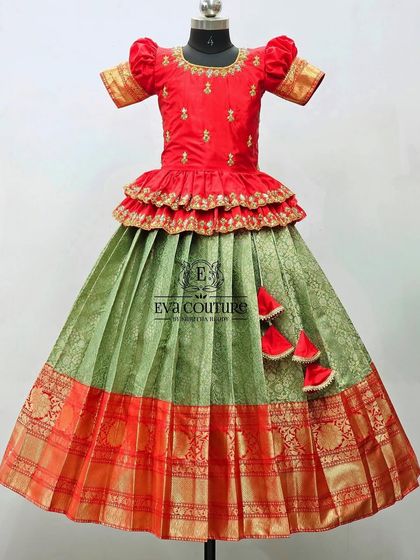 A red and green Banarasi lehenga with a tiered peplum blouse. A classic and festive combination.