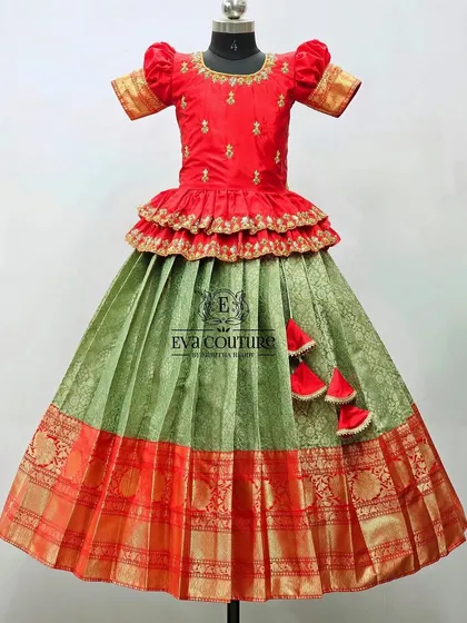 A red and green Banarasi lehenga with a tiered peplum blouse. A classic and festive combination.