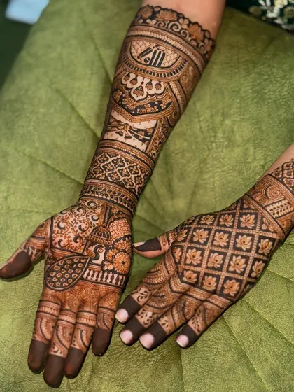 A gorgeous bridal design featuring a mix of grid patterns and traditional motifs. The peacocks on the palms are a classic symbol of beauty and grace in wedding mehendi.