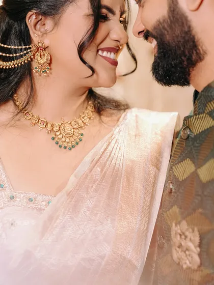 A close-up on the bride's smiling face, capturing her beautiful traditional jewelry and the happy glow of the celebration.