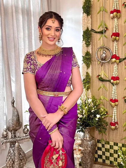 A full-length shot showing the elegant drape of the saree and the client's graceful posture.