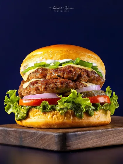 A classic double-patty smash burger, captured for Chili's 'Smasher Burgers' campaign. The focus is on creating a visually appealing, mouth-watering image that performs well for advertising and online menus, highlighting the texture of the patties and freshness of the ingredients.