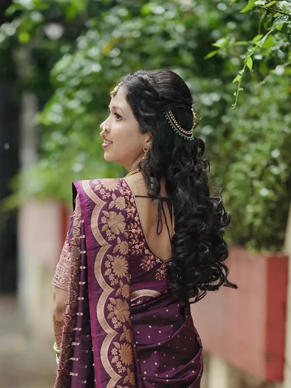 Another angle of the bride's hairstyle, showing the delicate hair accessory that adds a touch of sparkle to her open curls.