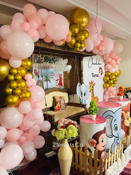 A unique fusion of a traditional Indian swing (jhoola) with a jungle theme. The pink and gold balloon arch beautifully frames the setup, blending modern decor with classic elements.