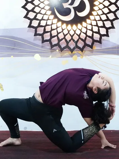 A deep backbend in a kneeling position, showing excellent spinal flexibility and strength.