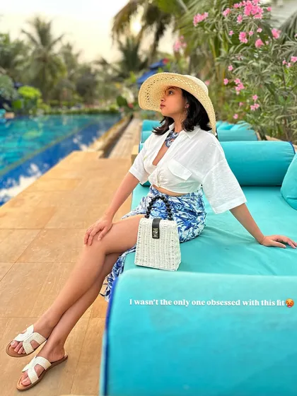 This was one of my favorite vacation fits. A blue and white printed skirt paired with a knotted white shirt, a straw hat, and a matching bag creates the perfect beach-chic look.