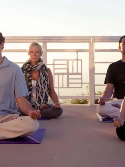 The Easy Pose, or Sukhasana, is a foundational pose for meditation and relaxation. As shown here with a group, simply sitting in a comfortable, cross-legged position can help center your thoughts and reduce anxiety.