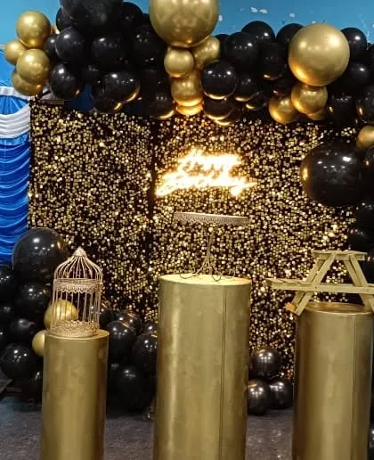 A luxurious black and gold theme with a sequin wall and matching balloon garland.