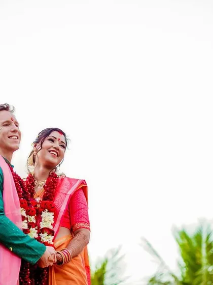 A minimalist portrait of the couple looking up at the sky, with two birds flying overhead. The composition uses negative space to create a feeling of freedom, hope, and a shared future.