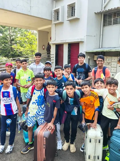 A happy group of young players, including a girl, arrive with their luggage for a residential camp. This photo perfectly captures the excitement and team spirit right from the start.