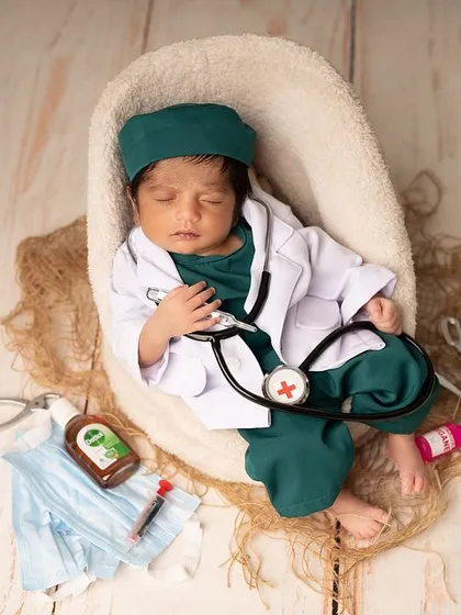 Celebrating our future heroes with a creative newborn photoshoot. This tiny doctor, sleeping peacefully with a miniature stethoscope, is a heartwarming way to honor a family's profession or simply create a unique and adorable memory.