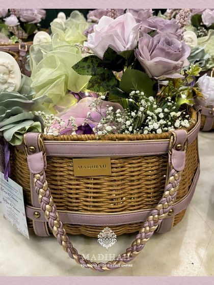 A high-angle shot of the Cane Arrival Basket, showing the lush arrangement of flowers and the elegant presentation. This is a perfect example of a stylish and thoughtful baby announcement gift.
