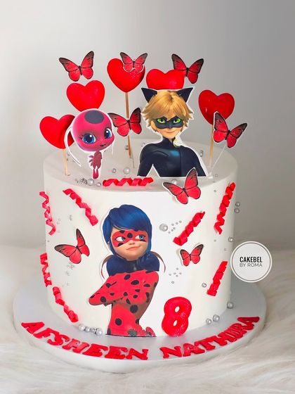 A vibrant Ladybug & Cat Noir cake for a fan's 8th birthday. The design is filled with red and black details, hearts, and butterflies to capture the romantic action of the Miraculous series.