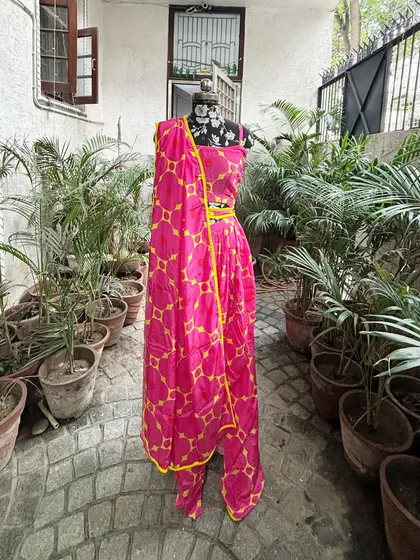 The full view of the pink and yellow dhoti set. It's a vibrant and playful outfit for any daytime celebration.