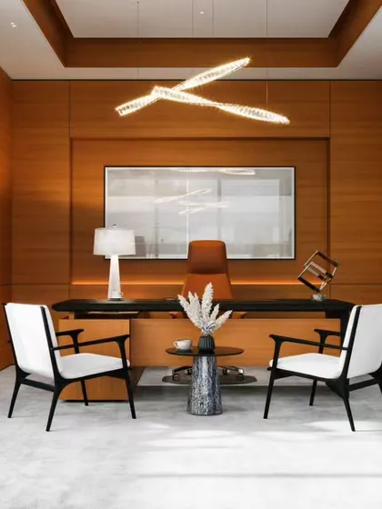 This executive cabin is designed for focus and authority. We used rich wood wall paneling to create a warm, sophisticated backdrop, paired with a sleek, modern desk and a striking contemporary chandelier that acts as a centerpiece.