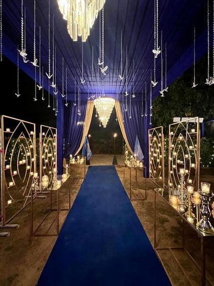 A stunning royal blue and gold entranceway for a New Year's Eve party. The candle-lit panels and hanging crystal birds created a magical, starry night effect.
