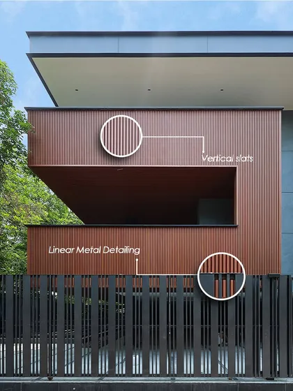 This facade creates a visual rhythm through an interplay of vertical slats and linear metal detailing on the fence and building. The details add texture and define proportion, creating a distinct architectural identity that is modern, minimal, and enduring.