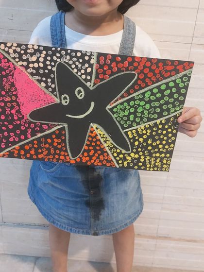 A close-up of a vibrant dot painting. This technique, inspired by pointillism, is a fun way to play with color and pattern, and it’s great for developing focus.