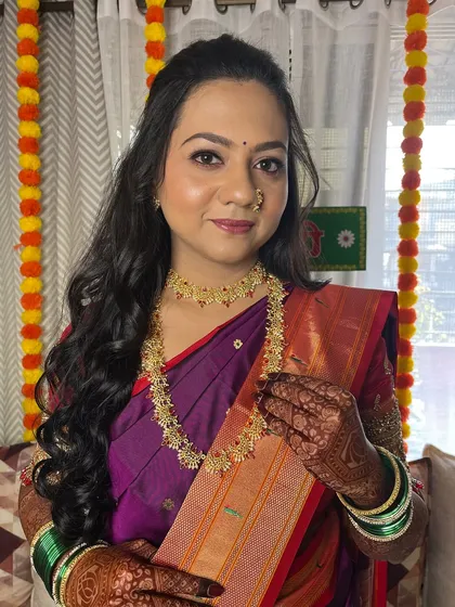 This shot highlights the intricate gold jewelry and how it complements the warm tones in her makeup.