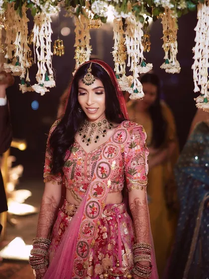 A close up of Pallavi's bridal look, showing the detailed embroidery on her lehenga and the soft glam makeup.