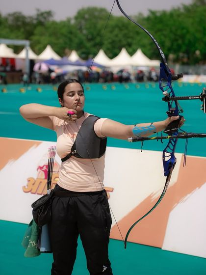 A powerful portrait of a female archer at full draw. This shot freezes a moment of intense concentration and strength, telling a story of dedication and skill. It's a key visual from my event coverage in Gujarat.