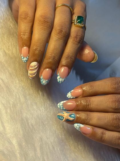 Get ready for the beach with these ocean-inspired nails. We created a textured, sea-foam effect on the tips and added a 3D starfish and seashell for a fun, vacation-ready look.