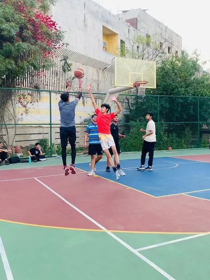 A player goes high for a rebound, showing the vertical leap we work on in our fitness sessions.