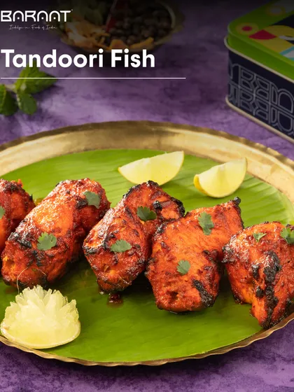 My Tandoori Fish, served on a banana leaf with lemon wedges, is a perfect appetizer for any meal.