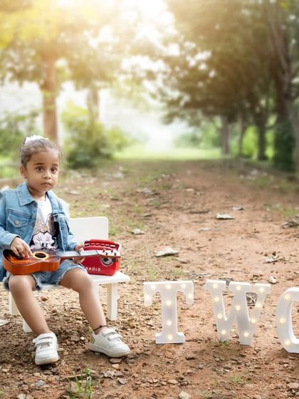 A wide shot of the outdoor second birthday setup, capturing the beautiful natural light and park setting.