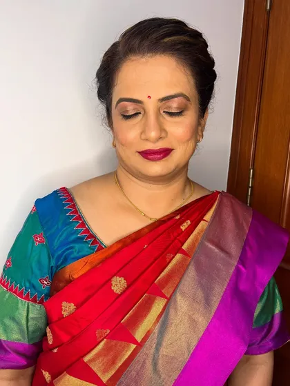 For this client, I created a sophisticated look with a bold berry lip and a clean, twisted updo, perfect for her colorful silk saree.