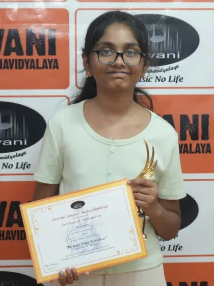 A student proudly holds her certificate and trophy.