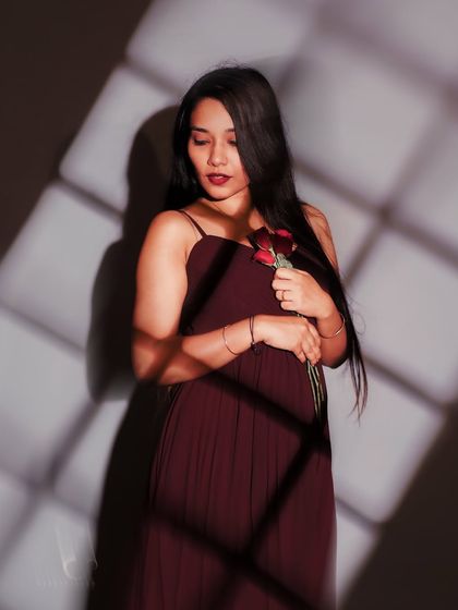 A gentle and serene portrait. The way she holds the rose close to her heart, combined with the soft light, creates a feeling of peace and quiet love.