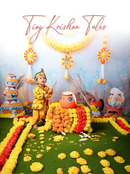 A playful little Kanha ready to break the dahi handi. The vibrant colors and traditional props in this setup create an authentic and joyful atmosphere.