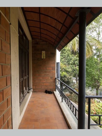 A balcony with a curved Hourdi block roof, offering a sheltered space to relax and enjoy the view of the garden.