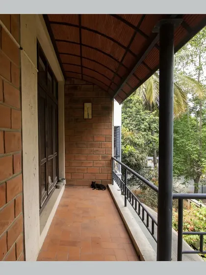 A balcony with a curved Hourdi block roof, offering a sheltered space to relax and enjoy the view of the garden.