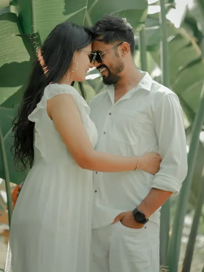An intimate moment with foreheads touching, framed by the vibrant green leaves of a Pune garden. This shot feels private and serene, perfectly capturing the couple's deep connection.