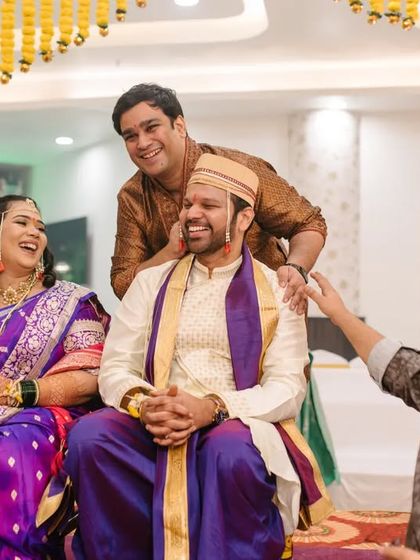 A candid moment of laughter and fun between the couple and their family during the wedding rituals.