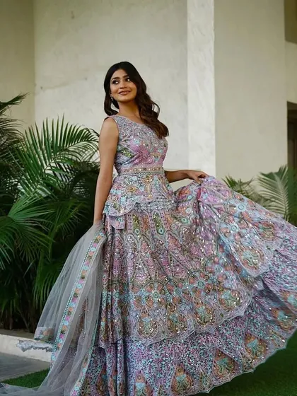 A model twirling in the multi-colored pastel lehenga, showing the beautiful movement and flare of the skirt.