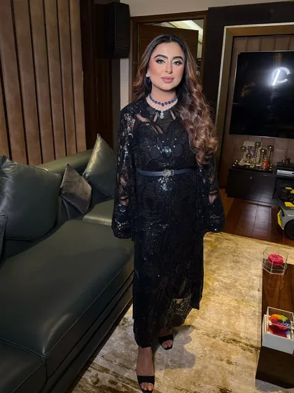 A full-length shot of the elegant black lace dress. The hair and makeup are styled to create a look of timeless Hollywood glamour.