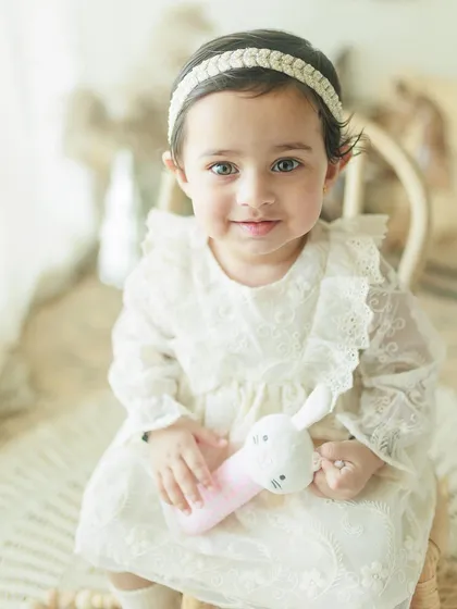 A beautiful close-up of a one-year-old girl during her birthday milestone shoot. Her bright eyes and sweet expression are the focus of this lovely portrait.