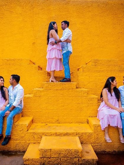 A creative and playful pre-wedding photo using a unique location with vibrant yellow steps. This composite shot captures different interactions, telling a small story within a single frame.