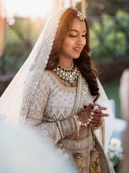 A stunning portrait of the bride, bathed in golden hour sunlight, looking serene and beautiful during her wedding ceremony.