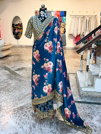 The full length of the 'NIKHAAR' saree shows its graceful drape and the stunning contrast between the printed body and the embellished border.