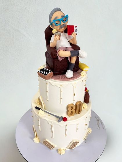 When a cake becomes a tradition. This two-tiered cake features a caricature of an 80-year-old grandfather chilling in his armchair, a design so loved he requested it two years in a row.