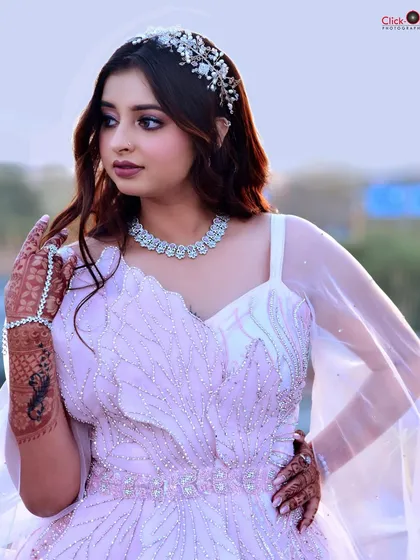 A soft and dreamy portrait from a pre-wedding shoot. The model wears a delicate light pink gown and a crystal headband, captured in beautiful golden hour lighting.