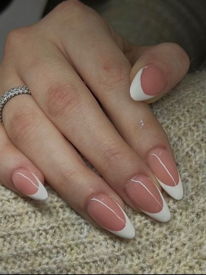 A beautiful example of a classic French manicure on sharp, almond-shaped nails, offering a sophisticated and polished look.