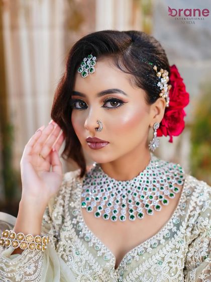 This portrait highlights the perfectly blended makeup and the striking contrast of the red rose against the elegant hairstyle.