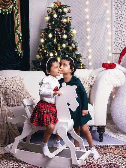 A sweet secret shared between sisters. This photo captures the special bond of siblings during the most wonderful time of the year.