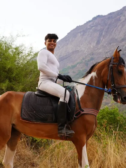 A rider enjoying the safari on a beautiful paint horse, showcasing the variety of horses available for our trail experiences.